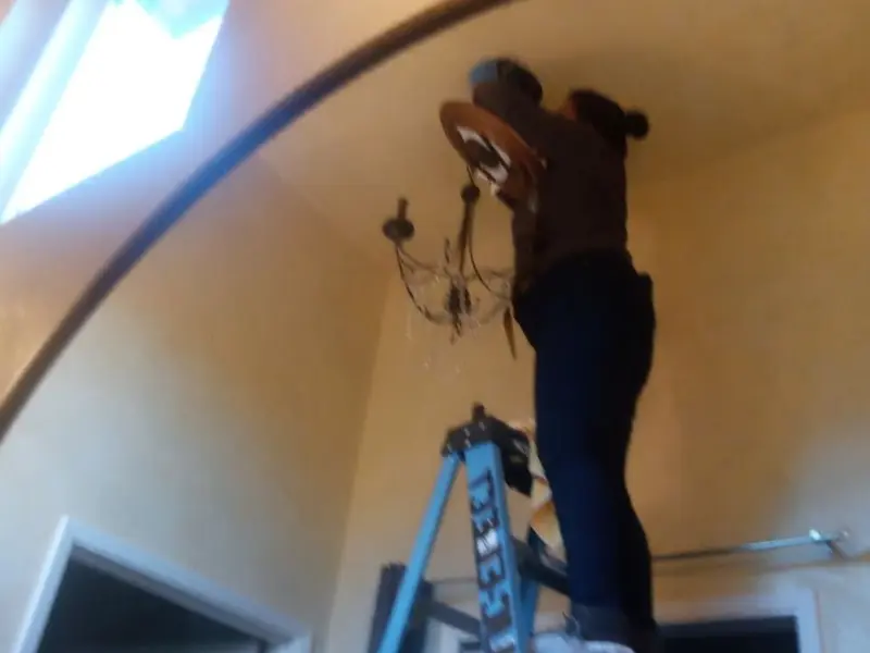 Electrician installing a chandelier in a Medulla residence